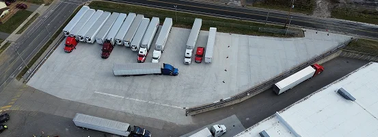 A high angle view of cars traveling on a road, surrounded by buildings and infrastructure, with an airport in the background.
