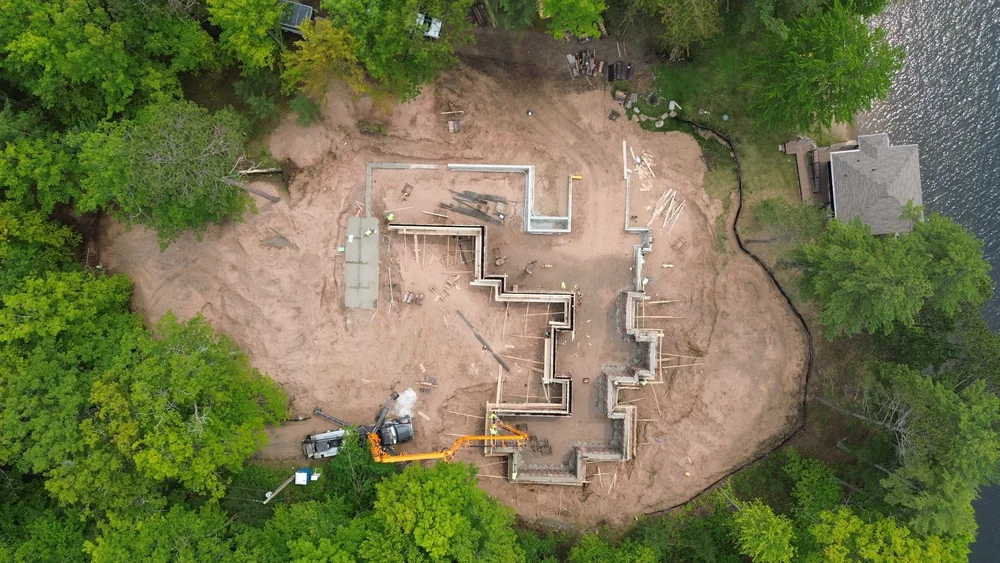 Aerial view of a construction site featuring a partially built structure surrounded by construction equipment and materials